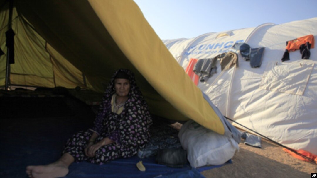 A Libyan refugee who fled unrest in Libya sit inside her tent at a refugee camp near the southern Libyan and Tunisian border crossing of Dehiba May 8, 2011.