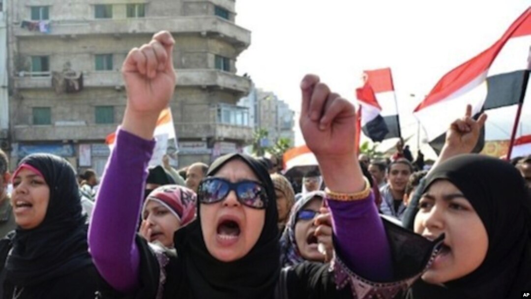 Egyptian protestors wave national flags and shout anti-government slogans during mass rally in the northern Mediterranean port of Alexandria on November 25, 2011.