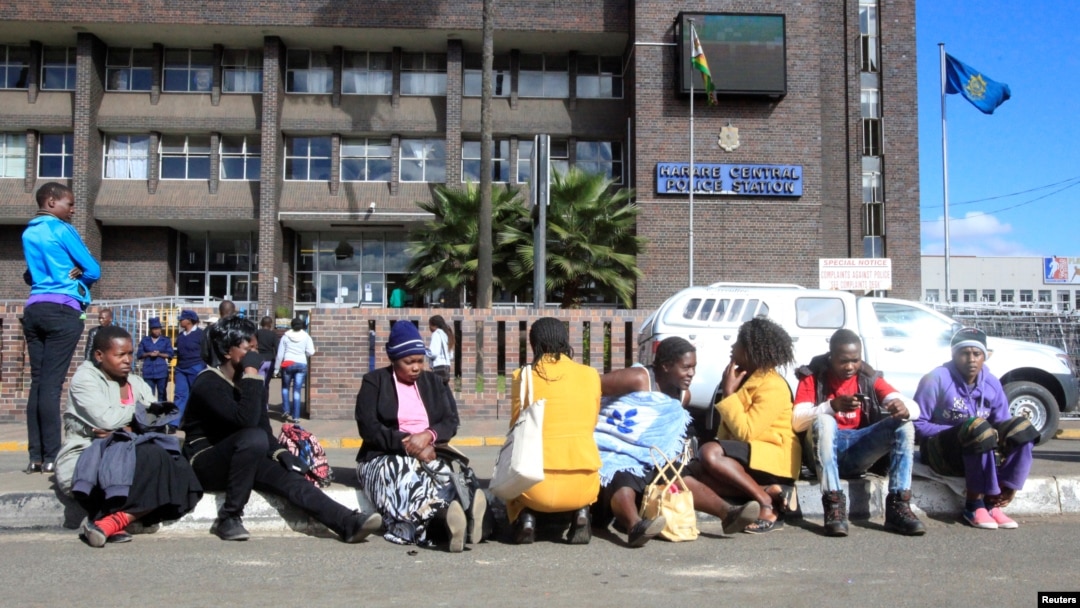 Zimbabweans wait outside the Harare Central Police station, in Zimbabwe, July 12, 2016, where Pastor Evan Mawarire (not in the picture), who organized a 'stay at home' anti-government protest last week appeared. 