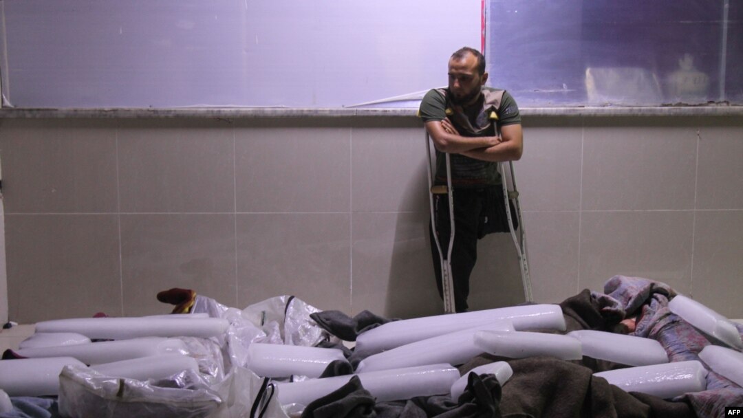 A Syrian amputee looks at bodies of civilians reportedly killed in regime airstrikes on Muhambal, in northern Idlib province, July 6, 2019. A Syrian regime bombardment killed 14 civilians, including seven children, a war monitor said.