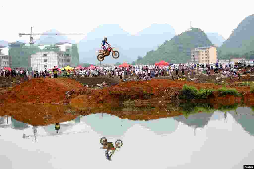 A rider rides a motorcycle in the air during a competition at Guilin, Guangxi Zhuang Autonomous Region, China.