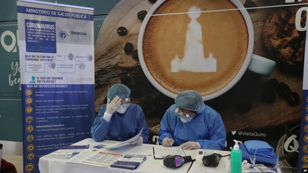 Health Ministry staffers prepare informational packets for travelers who are arriving on an international flights at the Mariscal Sucre Airport, in Quito, Ecuador, Feb. 29, 2020. 