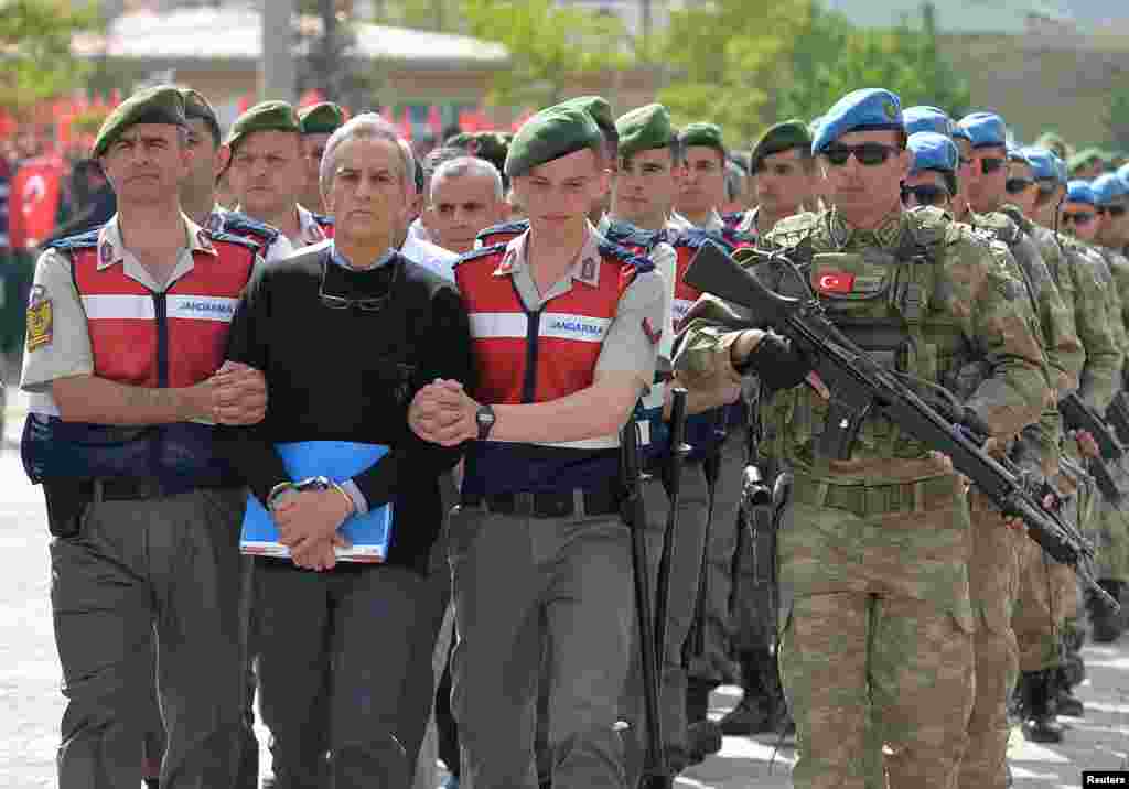 Akin Ozturk, a former Turkish Air Force commander who is accused of plotting and orchestrating last year's failed coup, is escorted by gendarmes as he arrives at the court in Ankara.