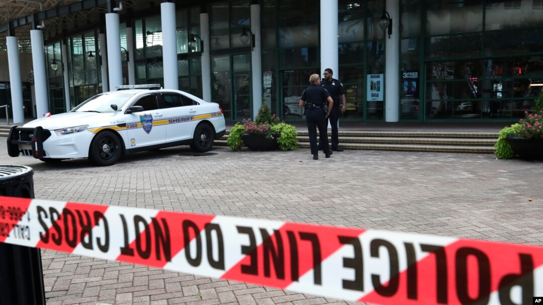 Jacksonville police officers guard an area, Aug. 27, 2018, near the scene of a fatal shooting at The Jacksonville Landing on Sunday in Jacksonville, Fla.
