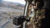 Taliban security personnel keep watch from a helicopter two days after airstrikes by Pakistan in the Barmal district of eastern Paktika province, Afghanistan, on Dec. 26, 2024.