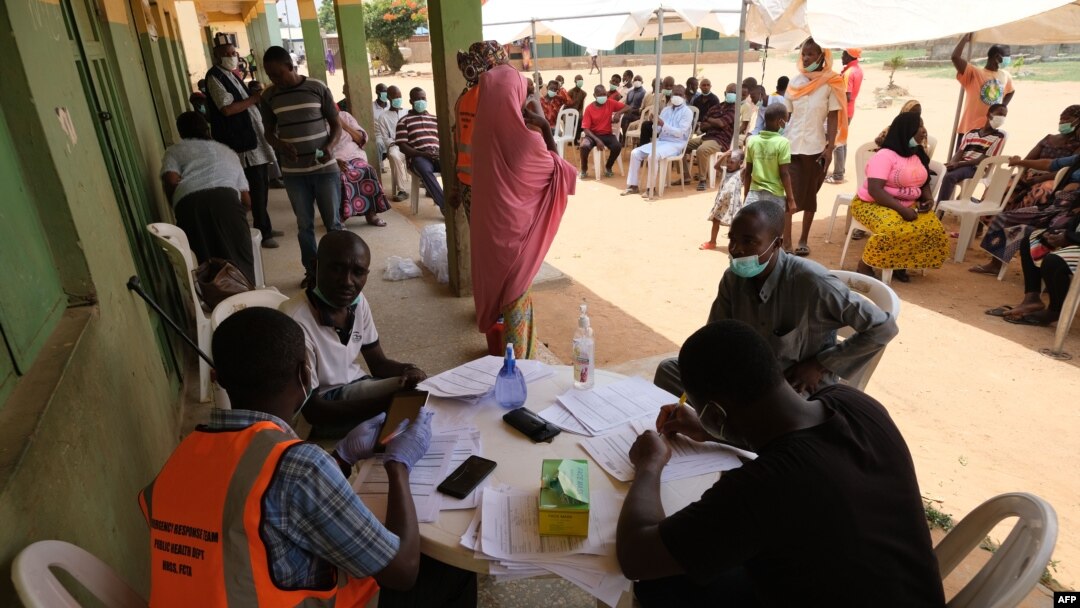 Health workers attend to people during a community COVID-19 coronavirus testing campaign in Abuja, Nigeria, on April 15, 2020.