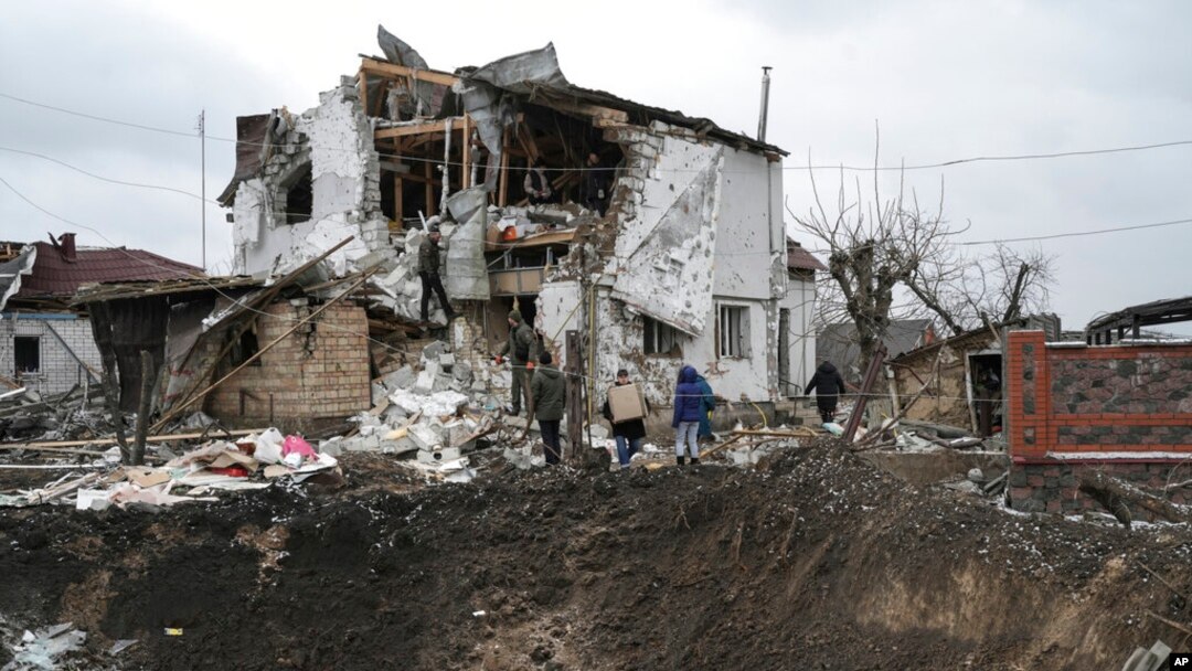 A crater of an explosion is seen next to a destroyed house after a Russian rocket attack in Hlevakha, Kyiv region, Ukraine, Jan. 26, 2023. 