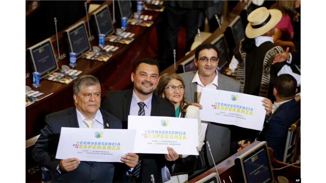 From left, Olmedo Ruiz, Sergio Marin, Sandra Ramirez and Jairo Quintero, all former members of the demobilized Revolutionary Armed Forces of Colombia, hold signs reading "Convergence for hope" at Congress before taking seats in the lower chamber of the newly elected legislature, in Bogota, Colombia, July 20, 2018.