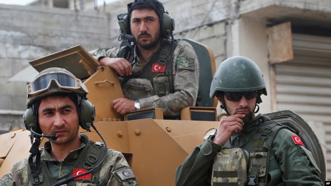 FILE - Turkish soldiers atop an armored personnel carrier secure the streets of the northwestern city of Afrin, Syria, March 24, 2018.