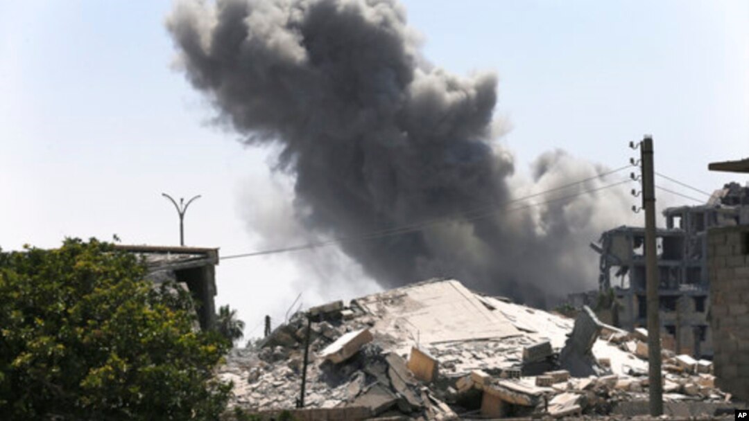 FILE - Black smoke rises from a coalition airstrike which attacked an Islamic State militant position, on the front line on the eastern side of Raqqa, Syria, July 26, 2017.