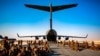 FILE - Marines assigned to the 24th Marine Expeditionary Unit await a flight to Kabul, Afghanistan, at Al Udeied Air Base, Qatar, Aug. 17, 2021. 