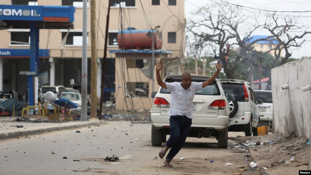 A man raises his hands as he runs from the scene of a suicide bomb attack outside the Hotel Naso-Hablod in Somalia's capital, Mogadishu, June 25, 2016.