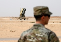 FILE - A member of the U.S. Air Force stands near a Patriot missile battery at the Prince Sultan air base in al-Kharj, central Saudi Arabia, Feb. 20, 2020.