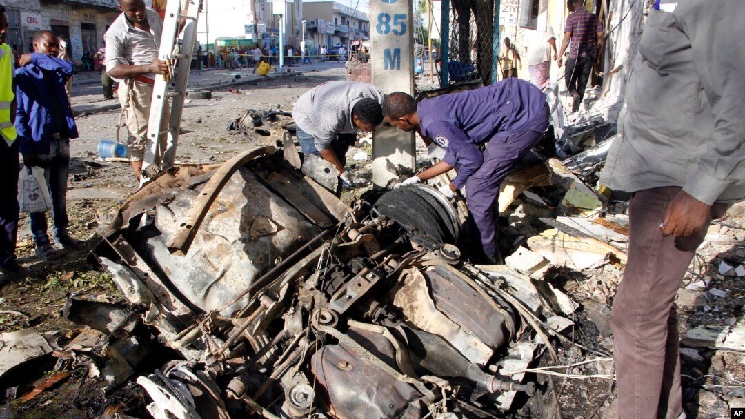 Somalian police examine the wreckage of the car after car bomb exploded in Mogadishu, Somalia, April 17, 2019.