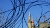 FILE - Turkish and Turkish Cypriot breakaway flags flying on the minarets of the Selimiye mosque or Agia Sofia, are seen through the barbed wires of the U.N. buffer zone that divides the Greek and Turkish Cypriots controlled areas, in the divided capital of Nicosia, Cyprus, Jan. 12, 2017.