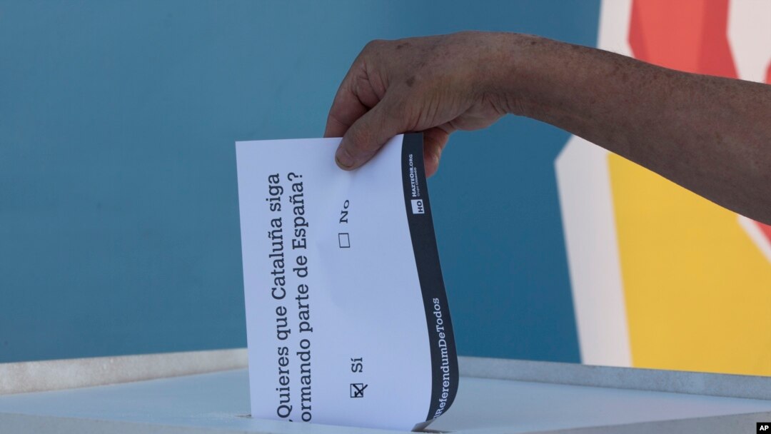 A man casts a symbolic 'No' vote during protest against the Catalonian referendum in Madrid, Spain, Friday, Sept. 29, 2017. 