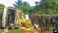 FILE - Congolese Defense Forces soldiers inspect the scene of an attack near the town of Oicha, 30 kms (20 miles) from Beni, Democratic Republic of Congo, July 23, 2021. 