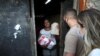 Daniele de Fatima, stands at her house in Cidade de Deus slum, as she receives food and bread from members of the Institute doAcao, which was produced at the Santuario de Nossa Senhora de Fatima, amid COVID-19 outbreak, in Rio de Janeiro, June 24, 2021.