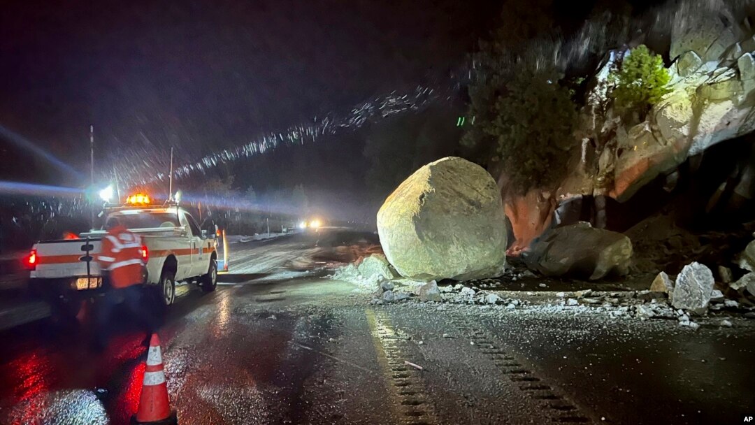 In this photo provided by Caltrans District 3, California Department of Transportation crews check large boulders that fell onto Highway 50 just east of Kyburz during a storm in El Dorado National Park, California, Jan. 1, 2023. 
