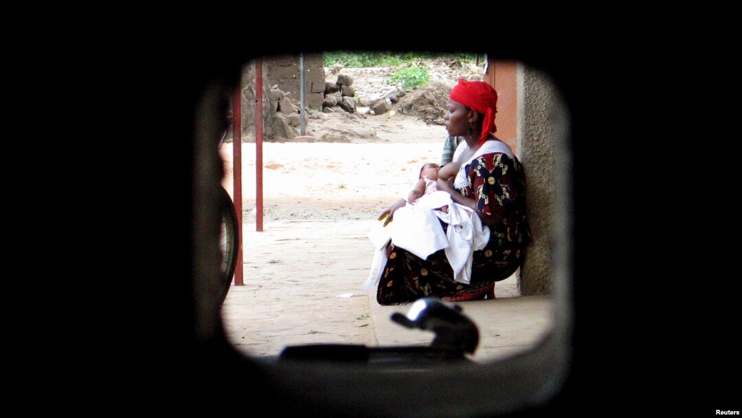 FILE - A woman sits with her child at a health clinic in Bujumbura, Burundi, Apr. 18, 2006. More than one million people die from malaria every year, almost 90 percent are in Africa. 