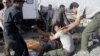 Brothers of an Afghan mini-bus driver who was killed in a suicide bombing cry at the scene, Sept. 18, 2012 in Kabul, Afghanistan. 