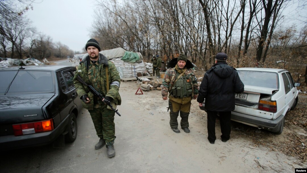 Pro-Russian separatists inspect cars at checkpoint in the Spartak area near the Sergey Prokofiev International Airport in Donetsk, Nov. 18, 2014. 