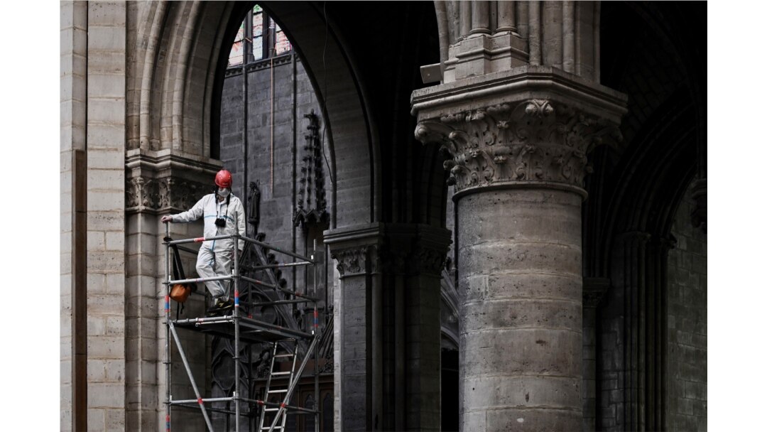 A worker stands on scaffolding during preliminary work inside the Notre Dame de Paris Cathedral, May 15, 2019, in Paris.