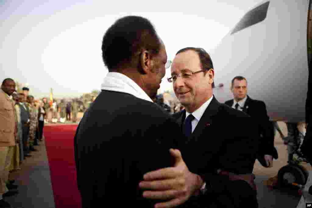 French President Francois Hollande, center right, is greeted by Mali's President Dioncounda Traore, as he arrives at the airport in Sevare, Mali, en route to Timbuktu, February 2, 2013. 