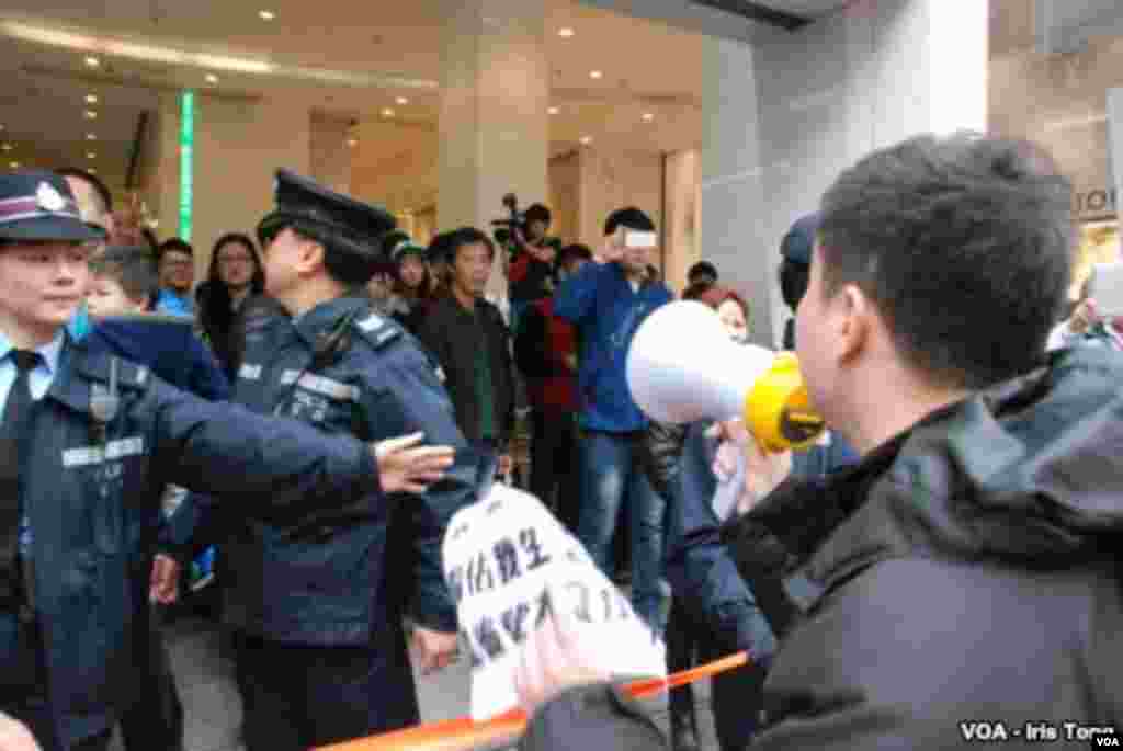 Hong Kong police set up a tape line to block the protesters from approaching the mainland shoppers. (Iris Tong, VOA)