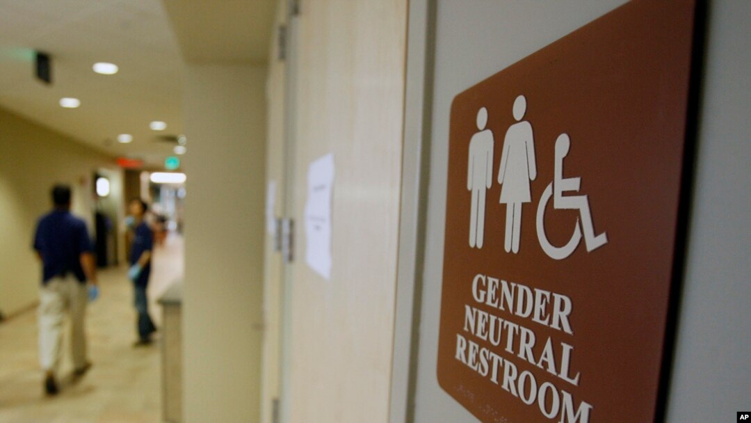 FILE- A sign marks the entrance to a gender-neutral restroom at the University of Vermont in Burlington, Vermont.