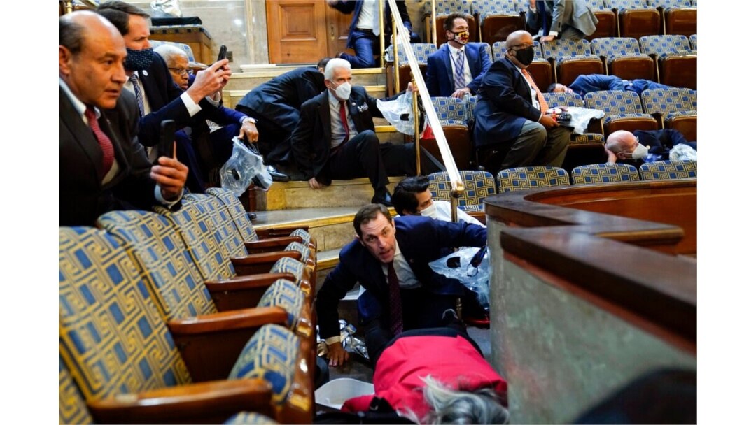 FILE - People shelter in the House gallery as protesters try to break into the House Chamber at the U.S. Capitol, Jan. 6, 2021.