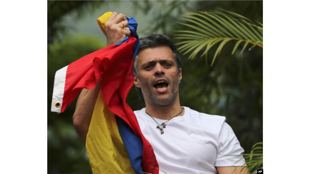 FILE - Venezuela's opposition leader Leopoldo Lopez holds a national flag as he greets supporters outside his home in Caracas, Venezuela, following his release from prison, July 8, 2017.