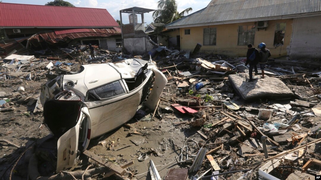 People survey the damage following a massive earthquake and tsunami at Talise beach in Palu, Central Sulawesi, Indonesia, Monday, Oct. 1, 2018. 