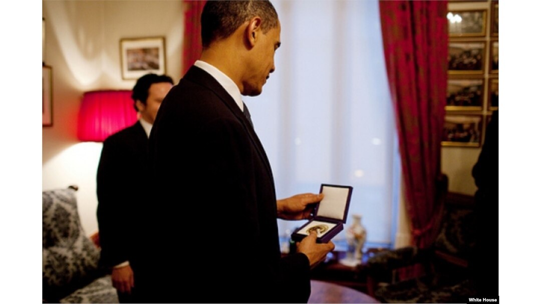 FILE - President Barack Obama looks at the Nobel Peace Prize medal for the first time at the Norwegian Nobel Institute in Oslo, Norway, Dec. 10, 2009. (White House/Pete Souza)