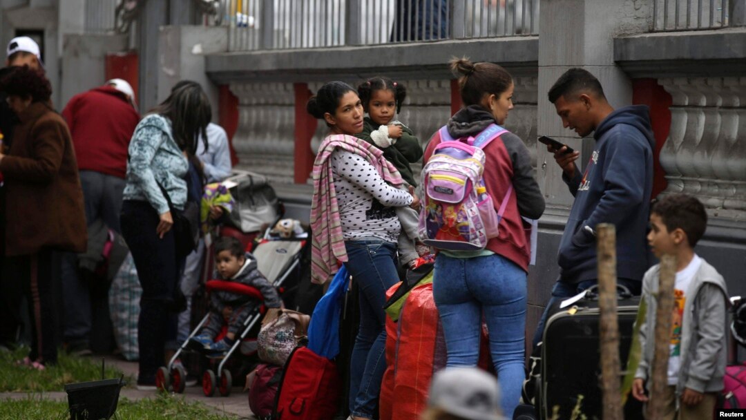 FILE - Venezuelan migrants wait on the grounds of their country's embassy for a bus that will transport them to the airport, in Lima, Peru, Sept. 8, 2018. 
