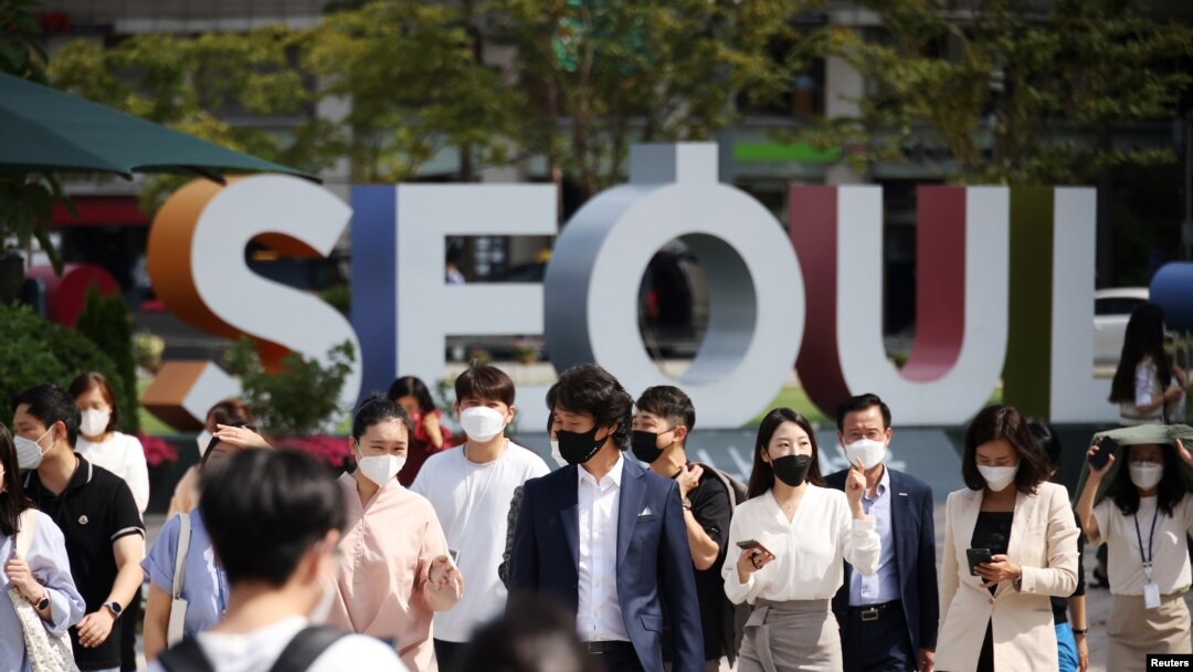 Commuters wearing masks to avoid contracting the coronavirus disease (COVID-19) cross a street in Seoul, South Korea, Sept. 24, 2021.