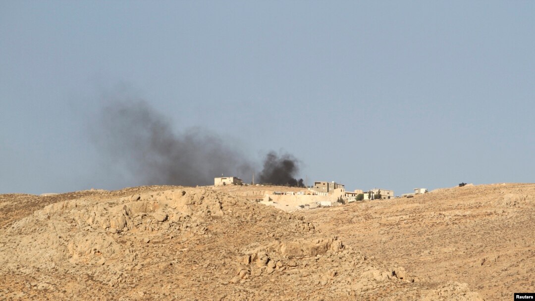 Smoke rises from a Lebanese army base as Lebanese Army soldiers clash with Islamist militants on the mountains next to the entrance of Arsal, August 3, 2014.