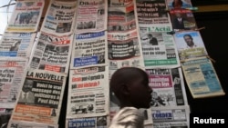 FILE - A boy walks past a newspaper kiosk at the Carrefour Wada district in the capital Yaounde, Oct. 7, 2011. Cameroon has been using its 2014 anti-terror law to threaten members of the media, according to a report by the Committee to Protect Journalists.