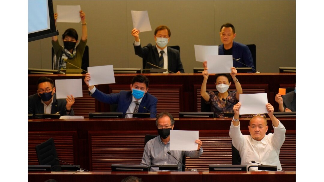 Pro-democracy lawmakers raise white papers to protest during a meeting to discuss the new national security law at the Legislative Council in Hong Kong, July 7, 2020.