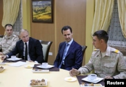 FILE - Russian President Vladimir Putin (2nd L) and Syrian President Bashar al-Assad (2nd R) meet with servicemen as they visit the Hmeymim air base in Latakia Province, Syria, Dec. 11, 2017.