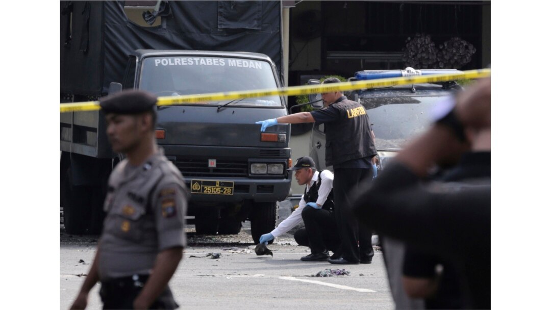 FILE - Members of police forensic team inspect the site of a bombing attack at the local police headquarters in Medan, North Sumatra, Indonesia, Nov. 13, 2019.