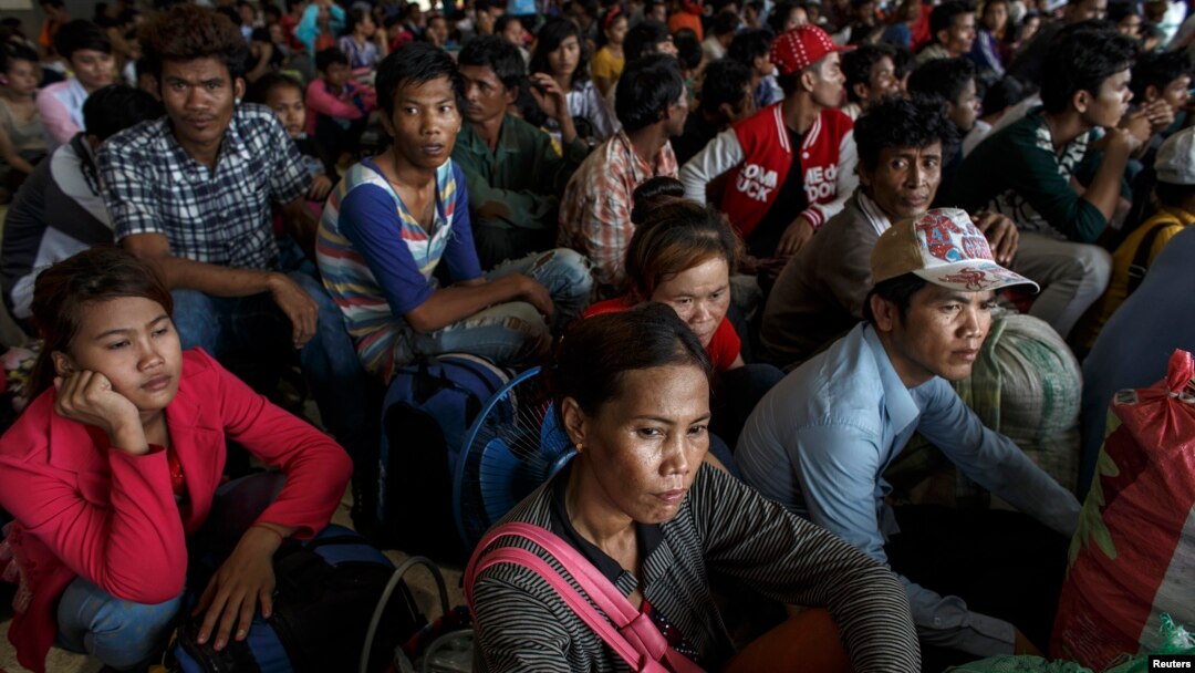 Cambodian workers wait for their documents to be processed at the Aranyaprathet police station as they prepare to move back to Cambodia, in Sa Kaew, Thailand, June 15, 2014.