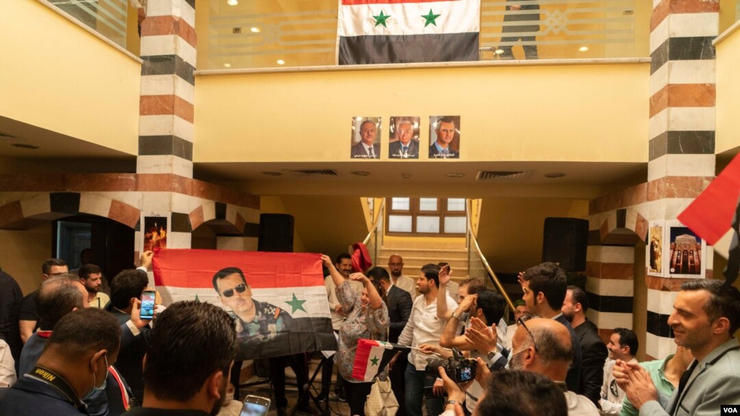 Quarters of the Syrian embassy in Cairo are cramped with patriotic Syrians singing national songs and raising Syrian flags depicting Bashar al-Assad. (Hamada Elrasam/VOA)
