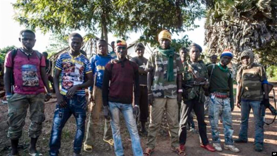 In this Aug. 28, 2014, photo an Anti-Balaka group that defends the Christian neighborhood near the Church of the city stands for a photo in Boda, Central African Republic. More than 5,000 people have died in sectarian violence in the Central African Republic since December, according to an Associated Press tally. (AP Photo/Sylvain Cherkaoui)