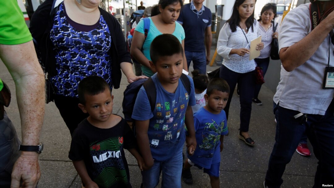 Migrant families from Mexico, fleeing from violence, walk toward the United States to meet officers of the U.S. Customs and Border Protection to apply for asylum at Paso del Norte international border crossing bridge in Ciudad Juarez, June 20, 2018. 