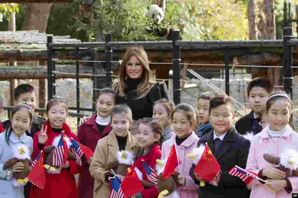 美国第一夫人梅拉尼娅&middot;川普参观北京动物园，，在熊猫馆附近，把美国秃鹰玩具送给欢迎她的儿童（2017年11月10日）。