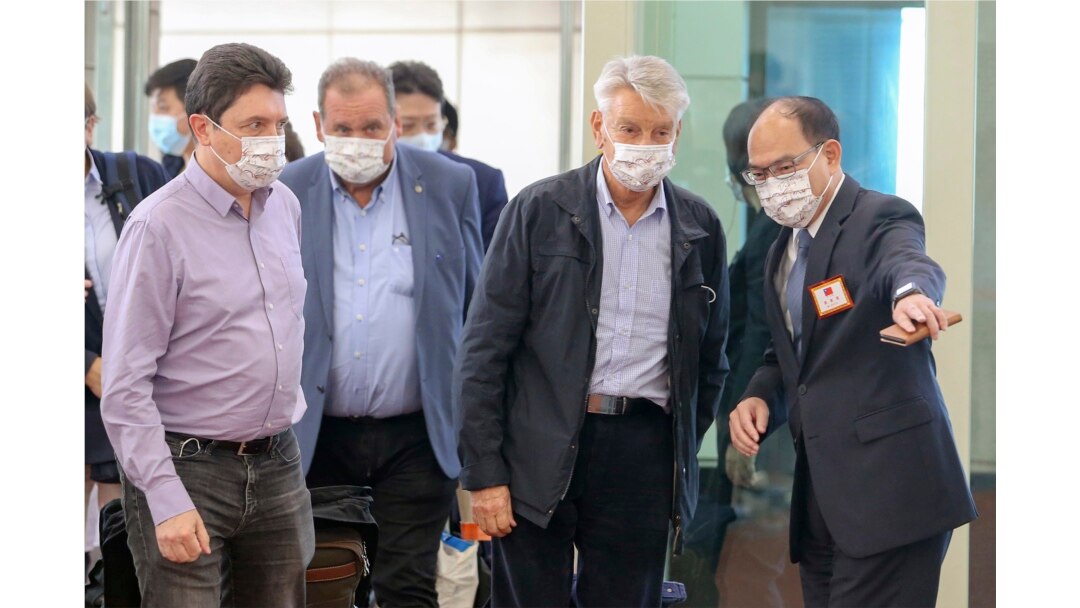 FILE - French senator Alain Richard, second right, is escorted by a Taiwanese official upon arrival at Taoyuan International Airport in Taiwan, Oct. 6, 2021. Richard led a group of French senators to Taiwan for a five-day visit.