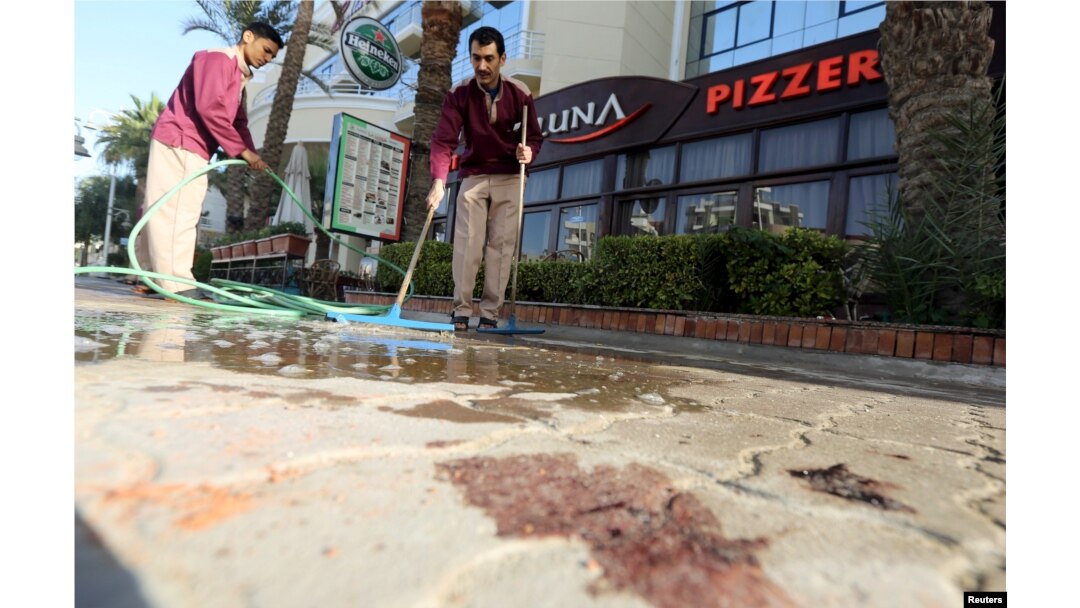 Cleaners try to clean blood stains near the entrance to Bella Vista Hotel in the Red Sea resort of Hurghada, Egypt, Jan. 9, 2016.