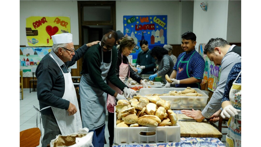 Dino Impagliazzo, Rome's 90-year-old 'chef of the poor', greets volunteers as they make sandwiches for the homeless living in the city.