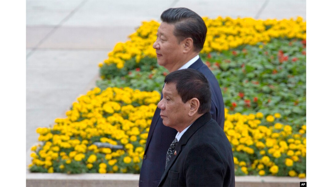 FILE - Philippine President Rodrigo Duterte, front, walks with Chinese President Xi Jinping during a welcome ceremony outside the Great Hall of the People in Beijing, China, Oct. 20, 2016.